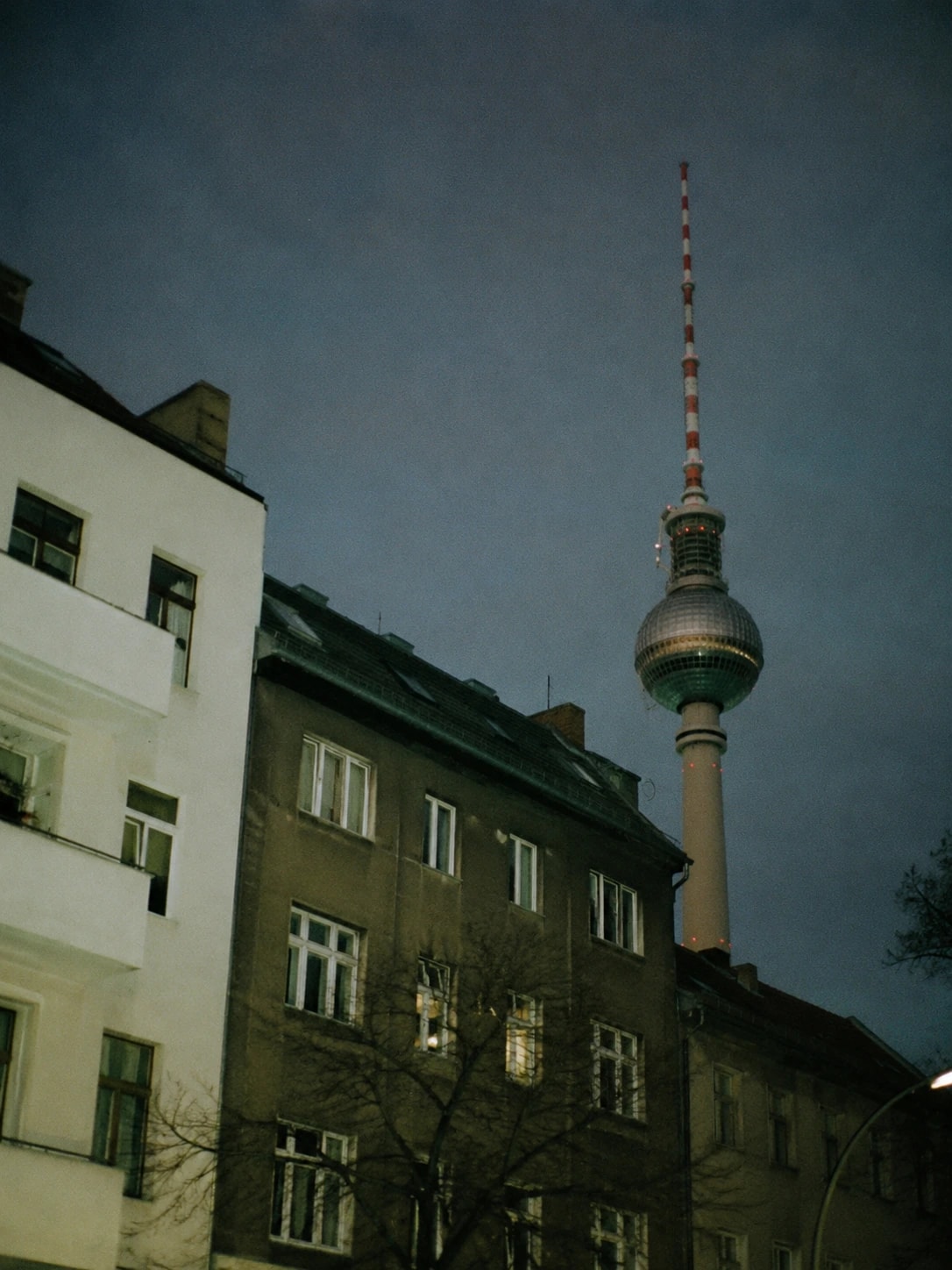 Berliner Fernsehturm über Wohnhäusern in der Dämmerung